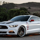 A photo of a white Ford Mustang with USA badges.